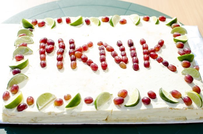 Zdjęcie przedstawiające ciasto w kształcie prostokąta z napisem "Piknik" utworzonym z czerwonych winogron